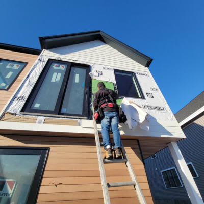 Contractor working on windows with a blue sky.