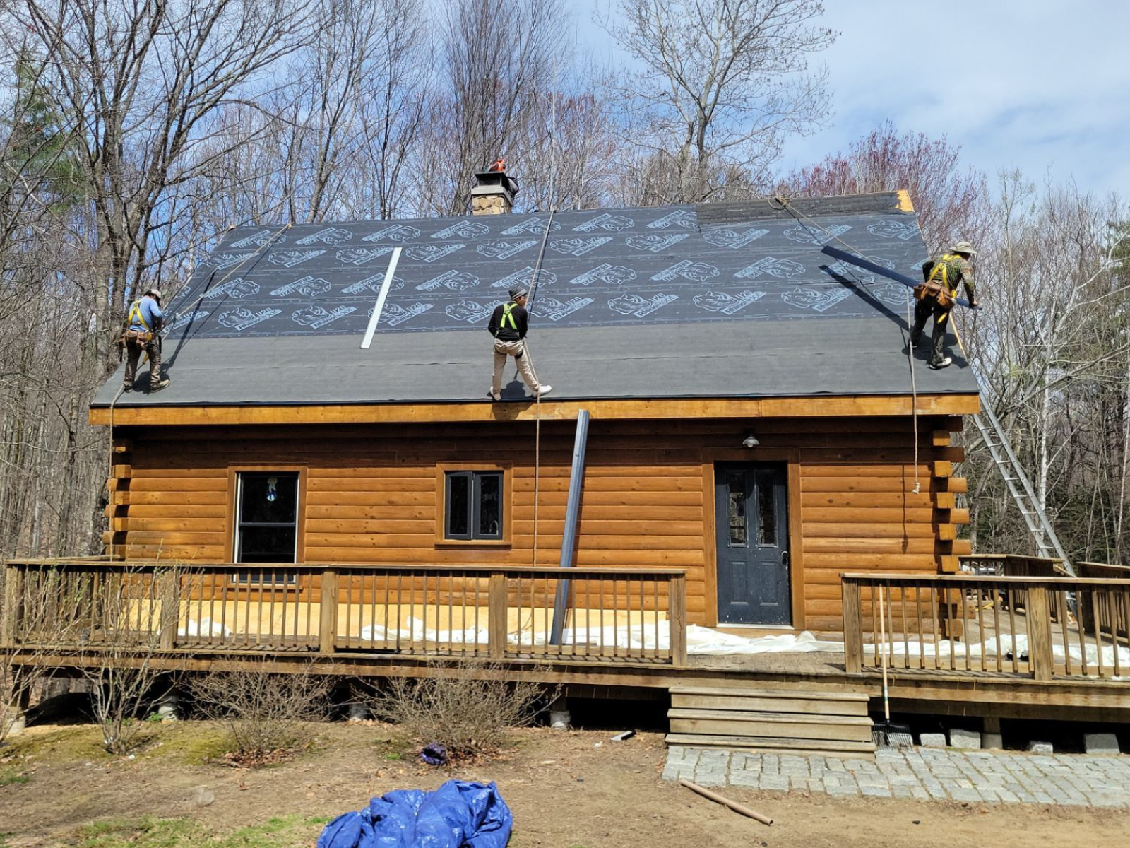 Roofers working on a pitched roof showing roof slope and underlayment